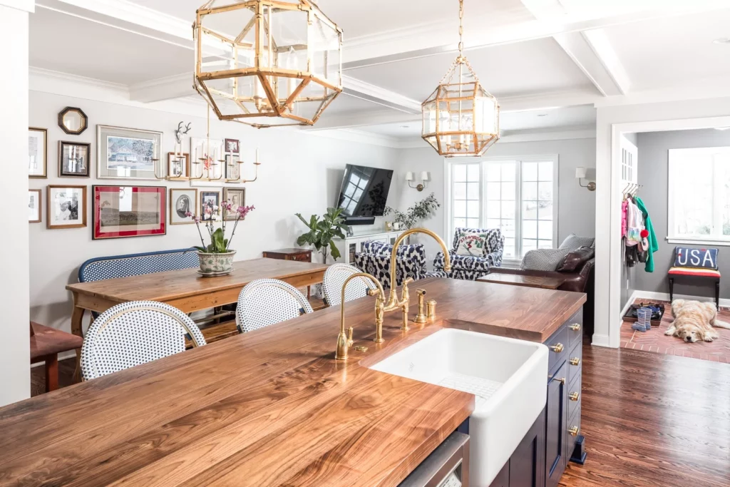 Luxury kitchen remodel and kitchen addition in colonial home. Traditional style, features island, butler's pantry, custom royal blue cabinetry and added family room. Dog in photo lying on floor next to island.