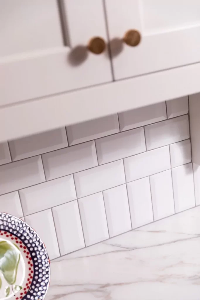 White tile brick backsplash under white cabinets