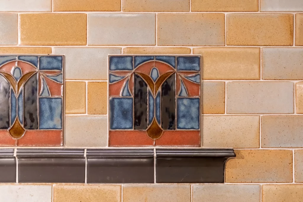 A blue and orange custom tile on yellow brick tile